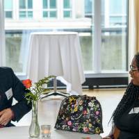 Two alumni sit at an event table